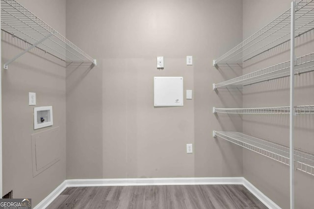 laundry room with washer hookup, wood finished floors, baseboards, and laundry area