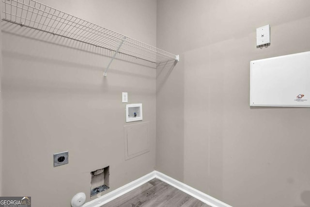 clothes washing area featuring wood finished floors, laundry area, washer hookup, hookup for an electric dryer, and baseboards