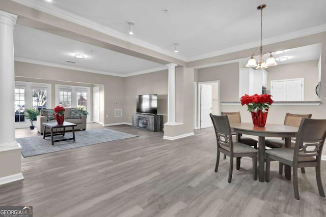 dining area with baseboards, ornate columns, and wood finished floors