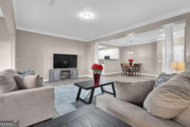 living room featuring ornamental molding, ornate columns, visible vents, light wood-style flooring, and baseboards