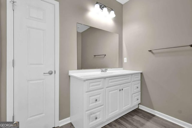 bathroom featuring vanity, baseboards, and wood finished floors