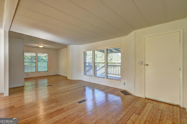 unfurnished living room with visible vents and hardwood / wood-style flooring
