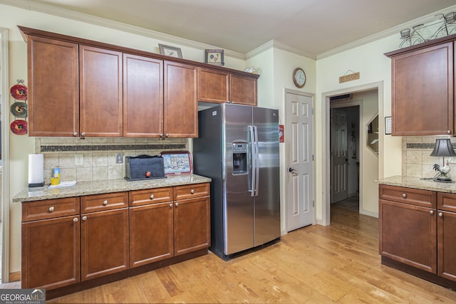 137 New Cut Rd, Winder, GA 30680 - kitchen with stainless steel fridge, crown molding, tasteful backsplash, light wood-type flooring, and light stone countertops
