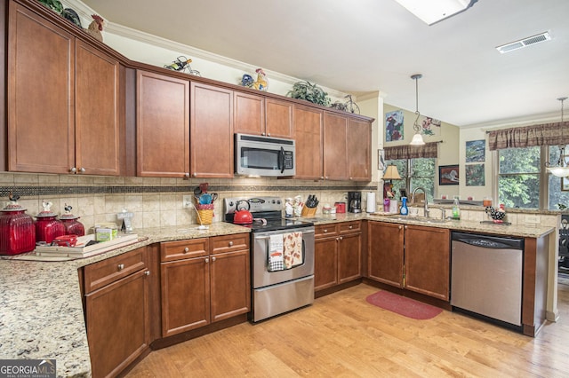 137 New Cut Rd, Winder, GA 30680 - kitchen featuring stainless steel appliances, a peninsula, a sink, light wood-style flooring, and backsplash