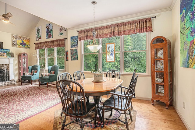 137 New Cut Rd, Winder, GA 30680 - dining room with light wood-style floors, a fireplace, ornamental molding, a ceiling fan, and baseboards