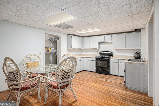 137 New Cut Rd, Winder, GA 30680 - kitchen with black range with electric cooktop, a sink, light countertops, light wood-type flooring, and a drop ceiling
