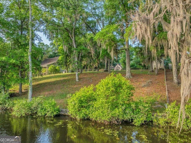 view of property's community with fence and a water view
