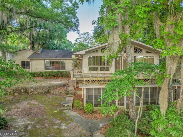 back of house featuring a wooden deck and a sunroom