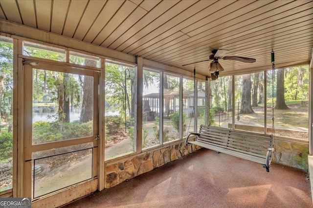 unfurnished sunroom with a water view and a ceiling fan