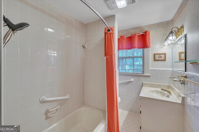 full bathroom with vanity, tile walls, bathing tub / shower combination, and visible vents