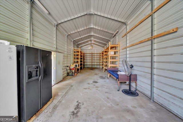 garage featuring metal wall and black refrigerator with ice dispenser