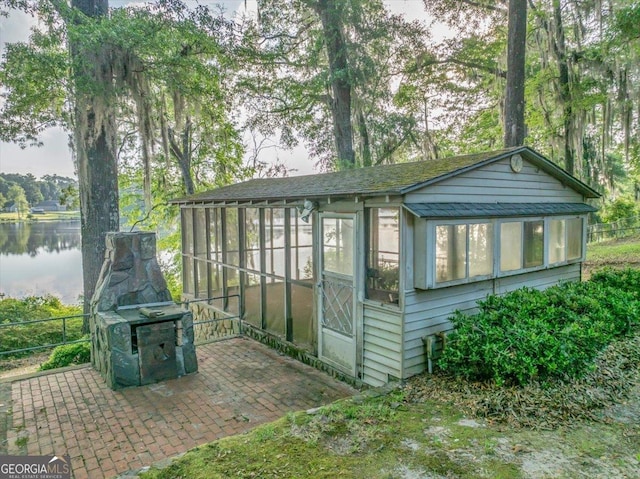 view of outbuilding with a water view and a sunroom