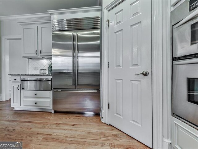 139 Grandmar Chase, Canton, GA 30115 - kitchen featuring light wood-style floors, a warming drawer, tasteful backsplash, and appliances with stainless steel finishes