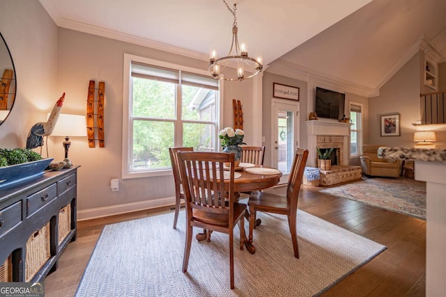 13 Jamilee Cv, Cartersville, GA 30120 - dining area with a notable chandelier, baseboards, wood-type flooring, a brick fireplace, and crown molding