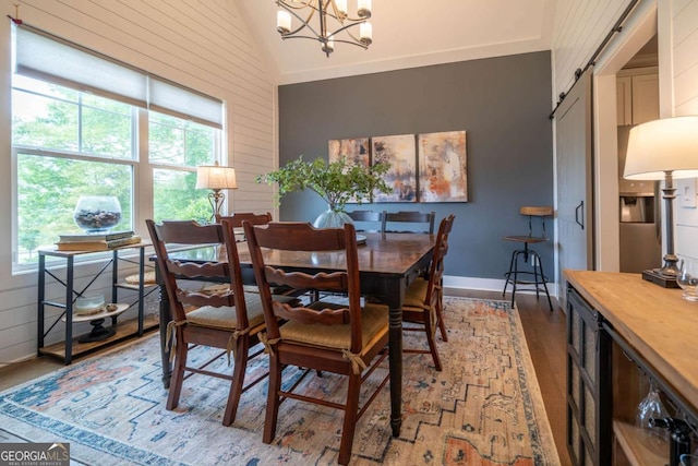 13 Jamilee Cv, Cartersville, GA 30120 - dining room with lofted ceiling, wood walls, baseboards, light wood finished floors, and a notable chandelier