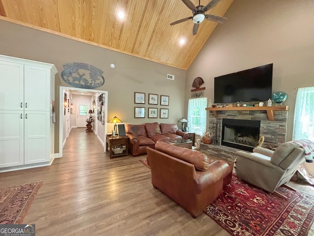 living room with light wood-type flooring, visible vents, ceiling fan, and high vaulted ceiling