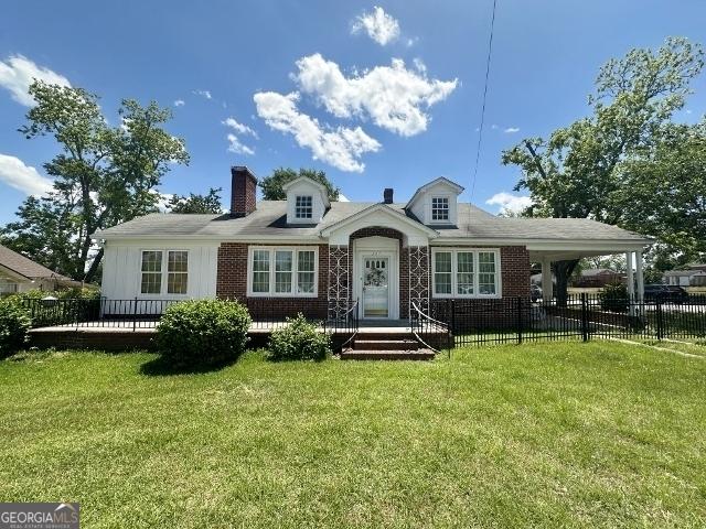 327 W Church St, Swainsboro, GA 30401 - view of front of property with a chimney, a front yard, brick siding, and fence