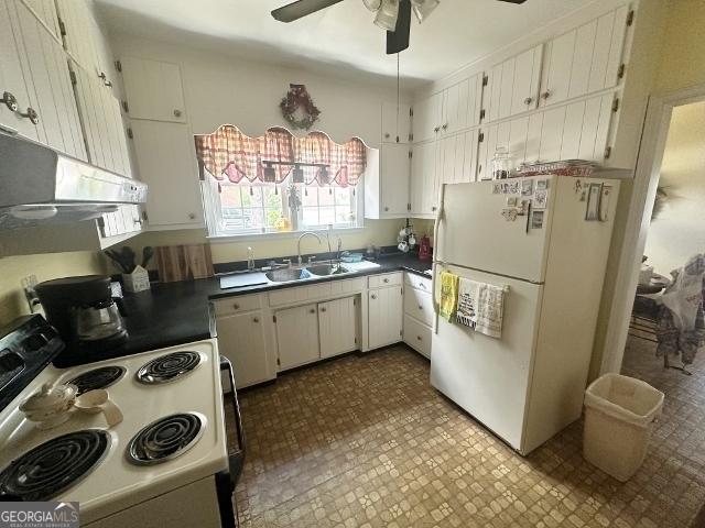 327 W Church St, Swainsboro, GA 30401 - kitchen featuring a sink, dark countertops, white cabinets, ceiling fan, and white appliances