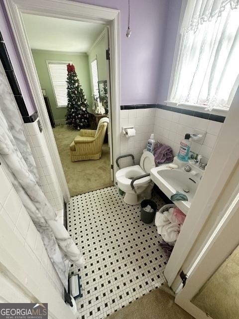 327 W Church St, Swainsboro, GA 30401 - bathroom featuring tile walls, toilet, and wainscoting