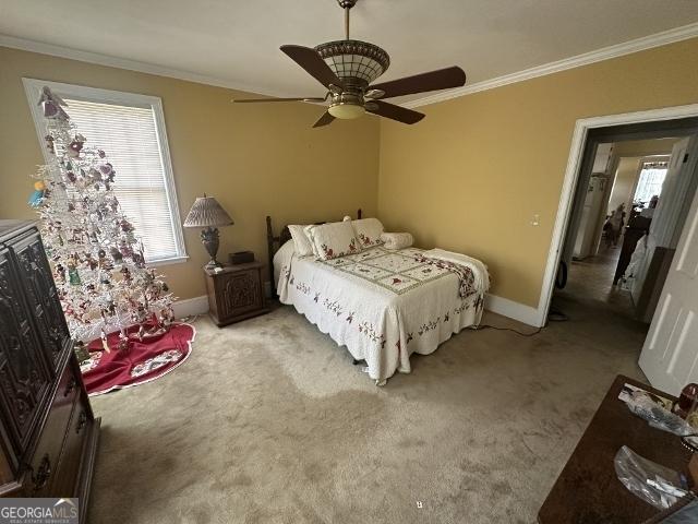 327 W Church St, Swainsboro, GA 30401 - bedroom featuring baseboards, multiple windows, crown molding, and light colored carpet