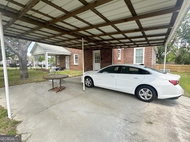 327 W Church St, Swainsboro, GA 30401 - view of parking / parking lot with fence and an attached carport