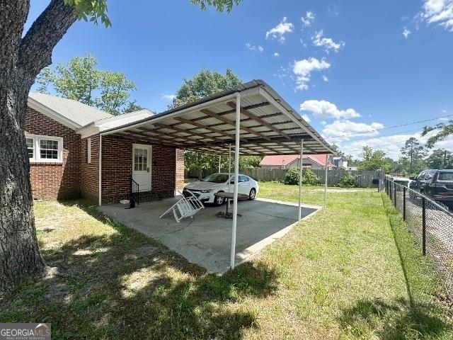 327 W Church St, Swainsboro, GA 30401 - view of parking / parking lot with fence and a carport