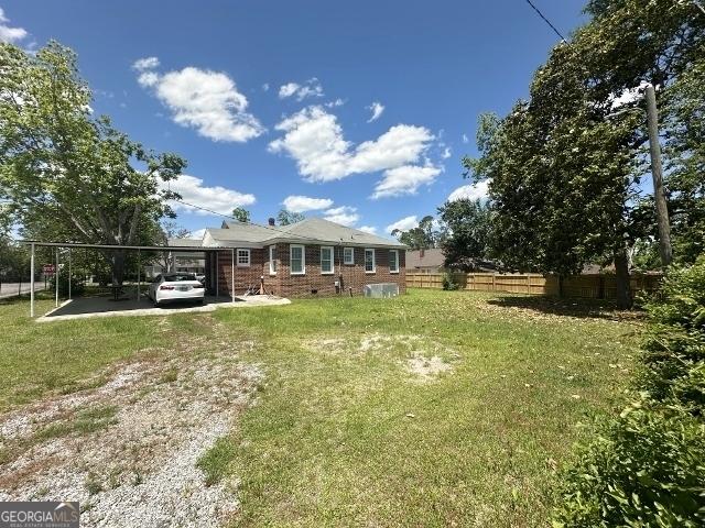 327 W Church St, Swainsboro, GA 30401 - view of yard featuring driveway, fence, and a carport