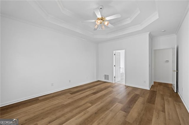 4368 Magnolia Bay Ln, Snellville, GA 30039 - spare room featuring a tray ceiling, a ceiling fan, ornamental molding, and wood finished floors
