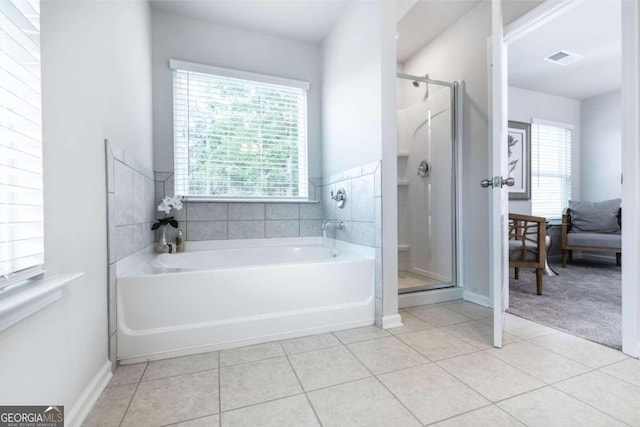 full bathroom featuring a shower stall, tile patterned flooring, and plenty of natural light
