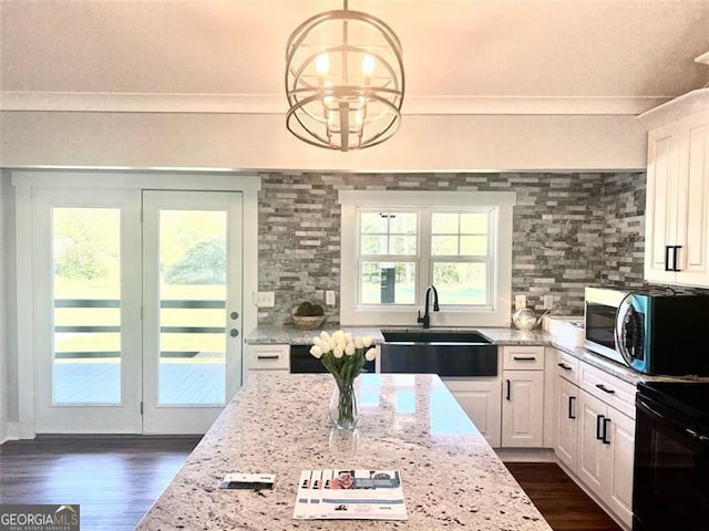 126 Arnold Rd, Statham, GA 30666 - kitchen with an inviting chandelier, a sink, dark wood-style flooring, stainless steel microwave, and light stone countertops