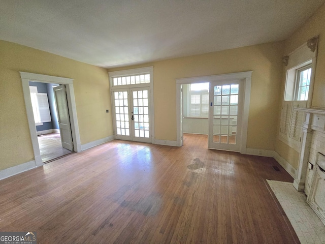863 Boulevard, Macon, GA 31211 - unfurnished living room featuring a wealth of natural light, baseboards, french doors, and wood finished floors