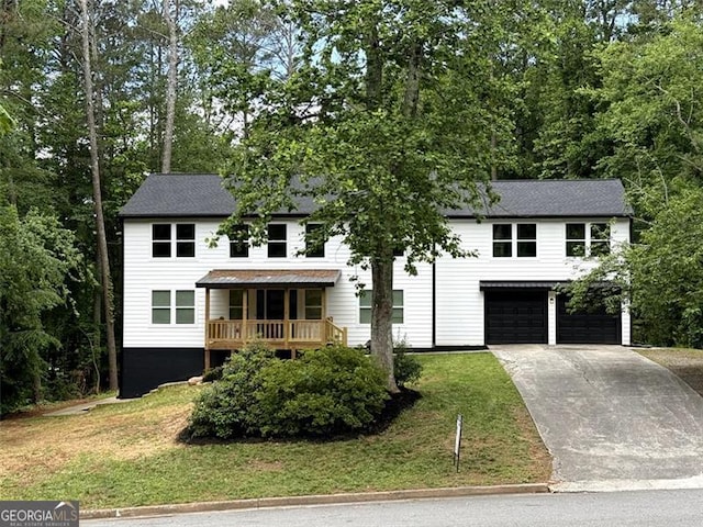 view of front facade featuring a garage, a front lawn, and driveway