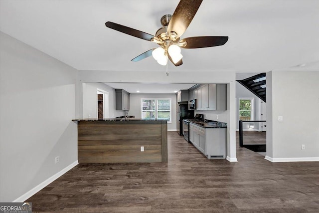 212 Lake Forest Dr, Acworth, GA 30102 - kitchen featuring dark countertops, gas stove, gray cabinets, and plenty of natural light
