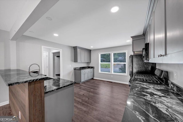 212 Lake Forest Dr, Acworth, GA 30102 - kitchen featuring gray cabinets, stainless steel gas range oven, dark stone counters, recessed lighting, and black microwave