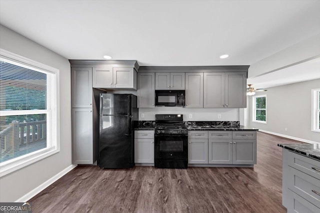 212 Lake Forest Dr, Acworth, GA 30102 - kitchen with black appliances, gray cabinets, dark wood finished floors, recessed lighting, and dark stone counters