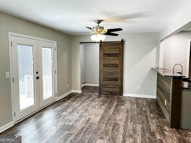 212 Lake Forest Dr, Acworth, GA 30102 - unfurnished living room with a barn door, dark wood-style floors, french doors, and ceiling fan