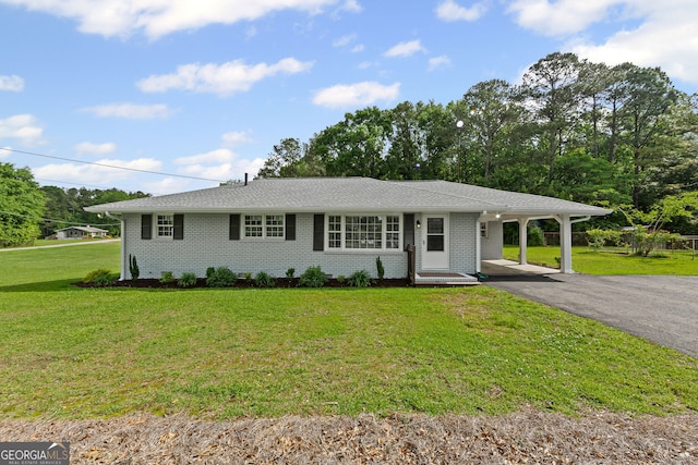 ranch-style house featuring driveway, brick siding, a front lawn, and a carport