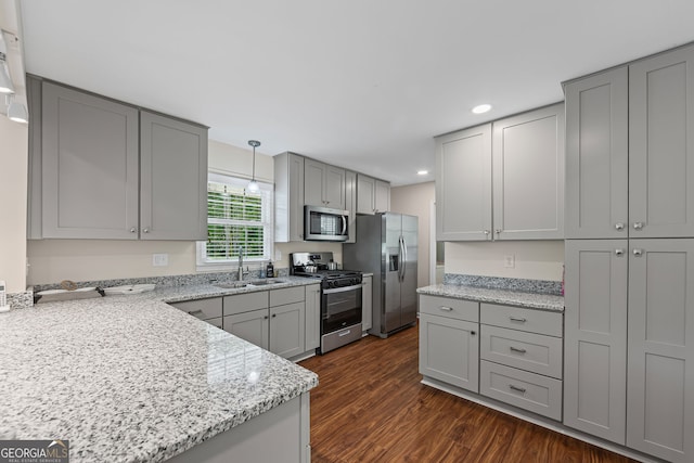kitchen featuring recessed lighting, dark wood finished floors, a sink, stainless steel appliances, and gray cabinets