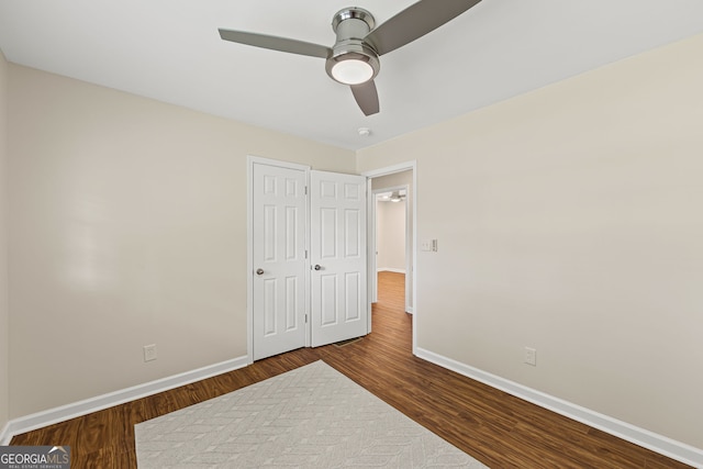 unfurnished bedroom with ceiling fan, baseboards, and wood finished floors