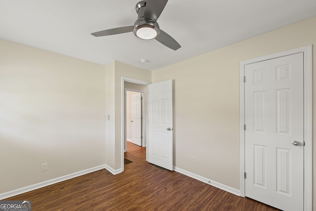 unfurnished bedroom with dark wood finished floors, baseboards, and ceiling fan