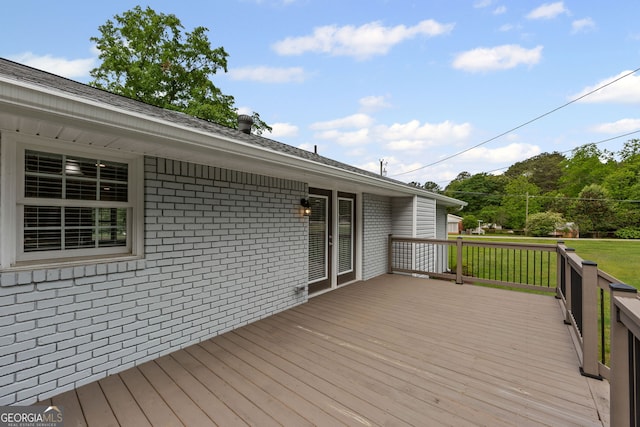 wooden terrace featuring a yard