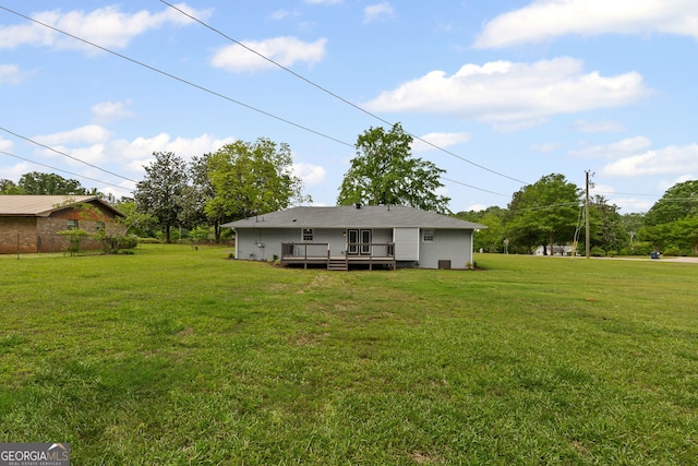 rear view of property with a deck and a lawn