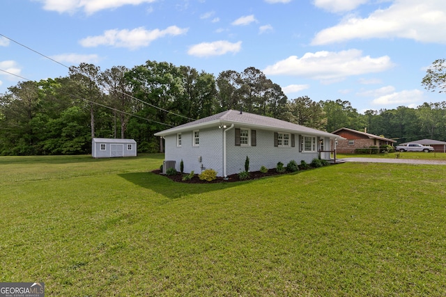 view of home's exterior featuring a storage shed, a lawn, central AC unit, an outdoor structure, and brick siding