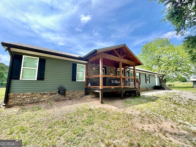 back of property with metal roof and a wooden deck