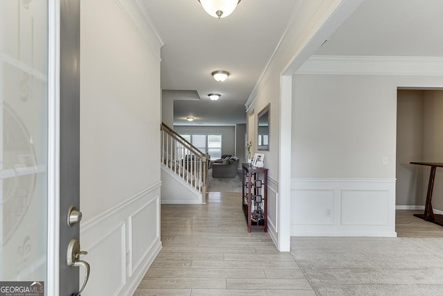 6438 Hickory Branch Dr, Hoschton, GA 30548 - entryway with a decorative wall, crown molding, wainscoting, light wood-type flooring, and stairway