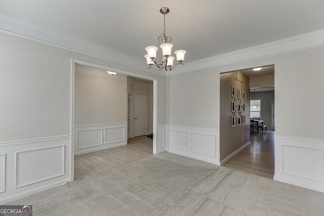 6438 Hickory Branch Dr, Hoschton, GA 30548 - unfurnished room with a chandelier, a decorative wall, crown molding, wood finished floors, and a wainscoted wall