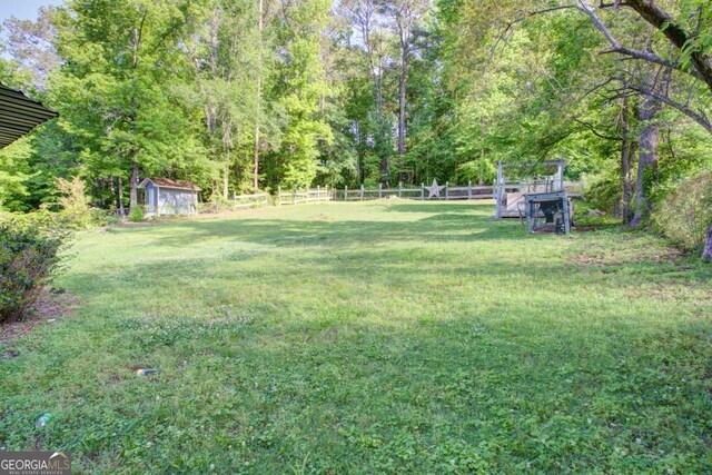3627 Groovers Lake Rd, Lithia Springs, GA 30122 - view of yard with an outdoor structure, a view of trees, and a storage unit