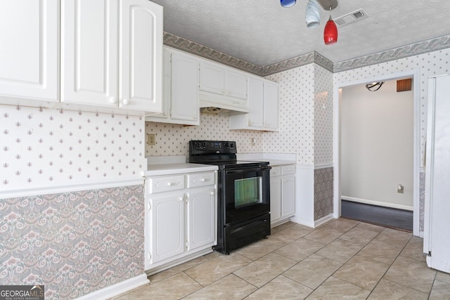 kitchen with black electric range, visible vents, white cabinets, and wallpapered walls