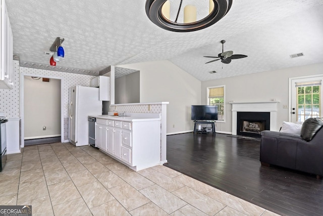 kitchen with ceiling fan, a textured ceiling, light countertops, and white cabinets