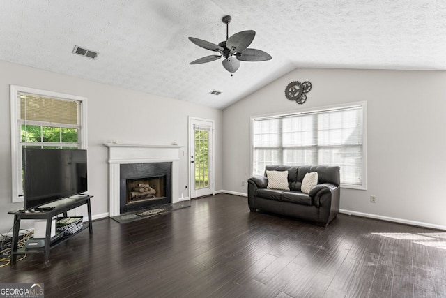 living area featuring a textured ceiling, a high end fireplace, a ceiling fan, and visible vents